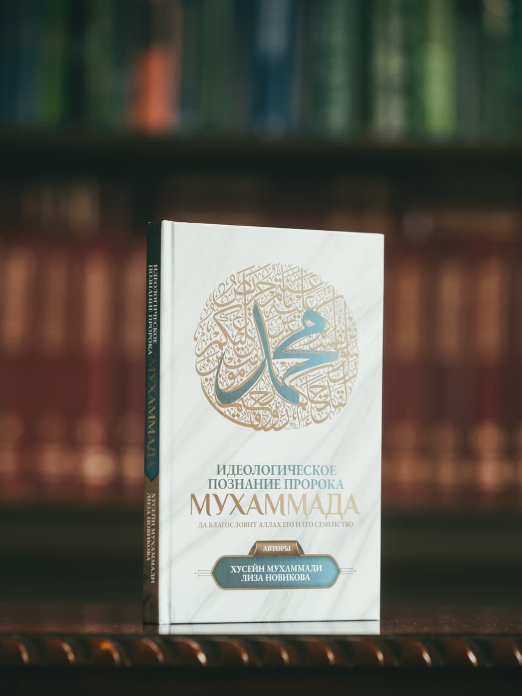 Книга «Идеологическое познание Пророка Мухаммада» на фоне библиотеки