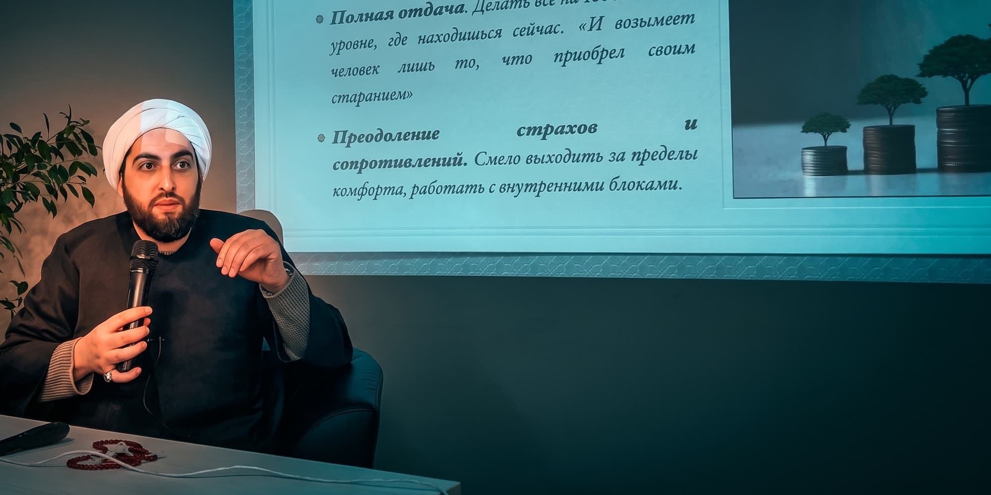 Учитель Хусейн ведёт семинар в Казани, за спиной экран со слайдом